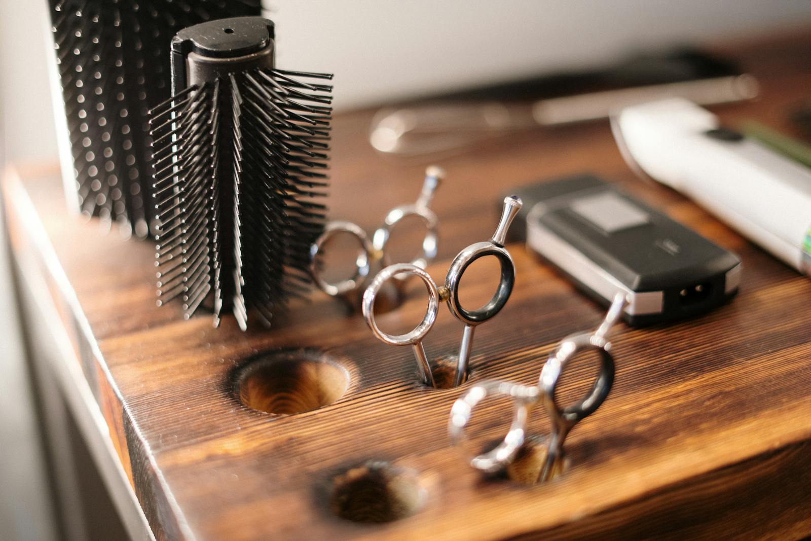 Barber scissors and combs on wooden station at Hairrari Bushwick, warm tungsten light